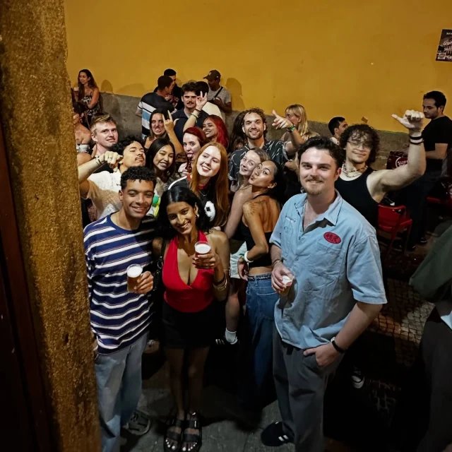 A big group of guests together at the hostel bar